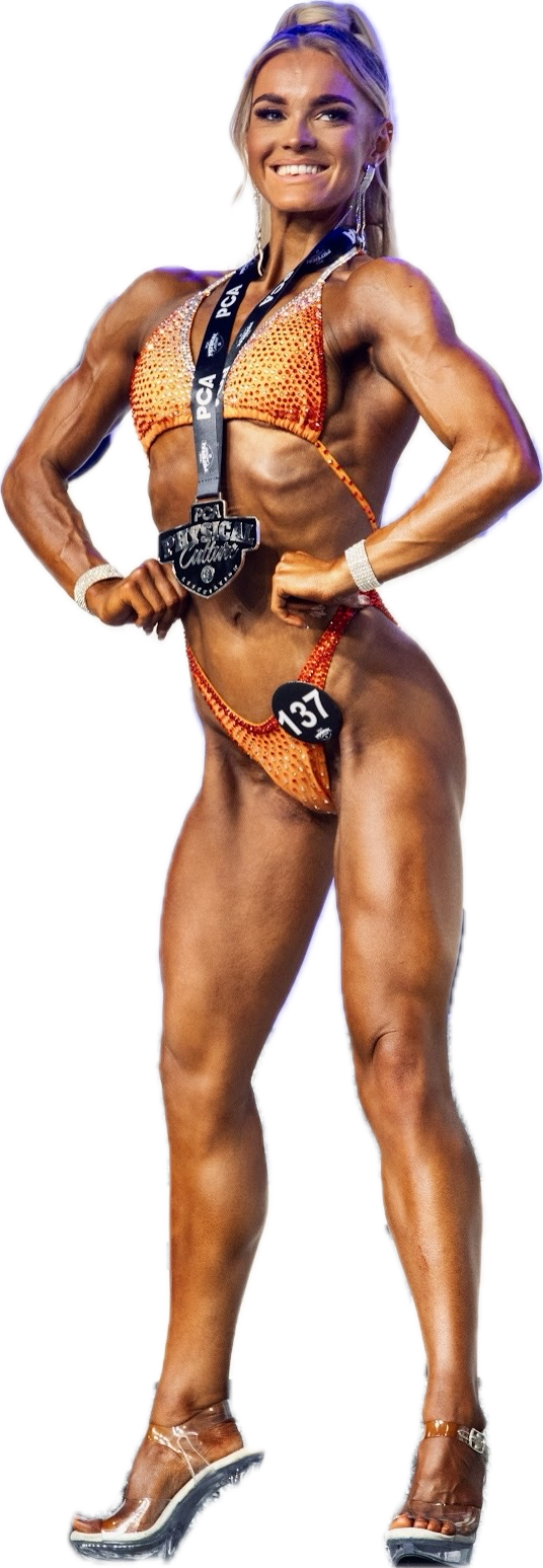 A shirtless man in shorts is standing with his hands on his hips.