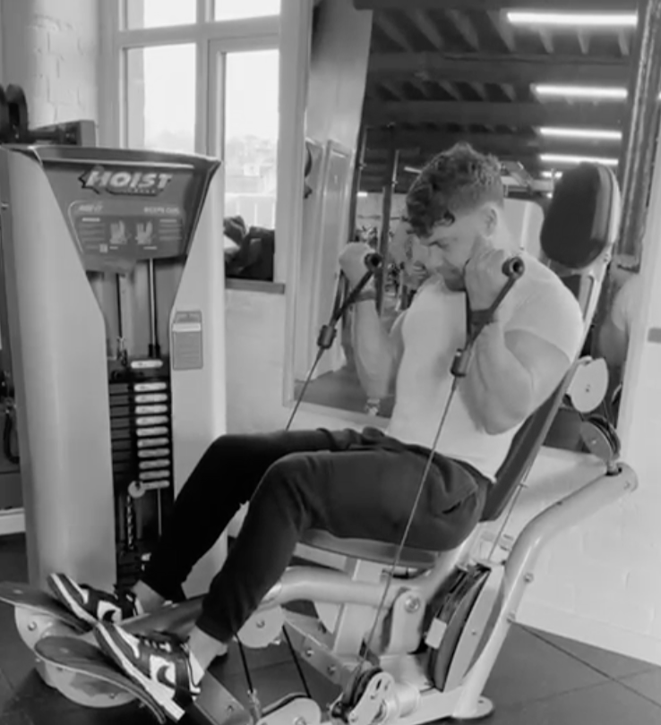 A man is using a hoist machine in a gym