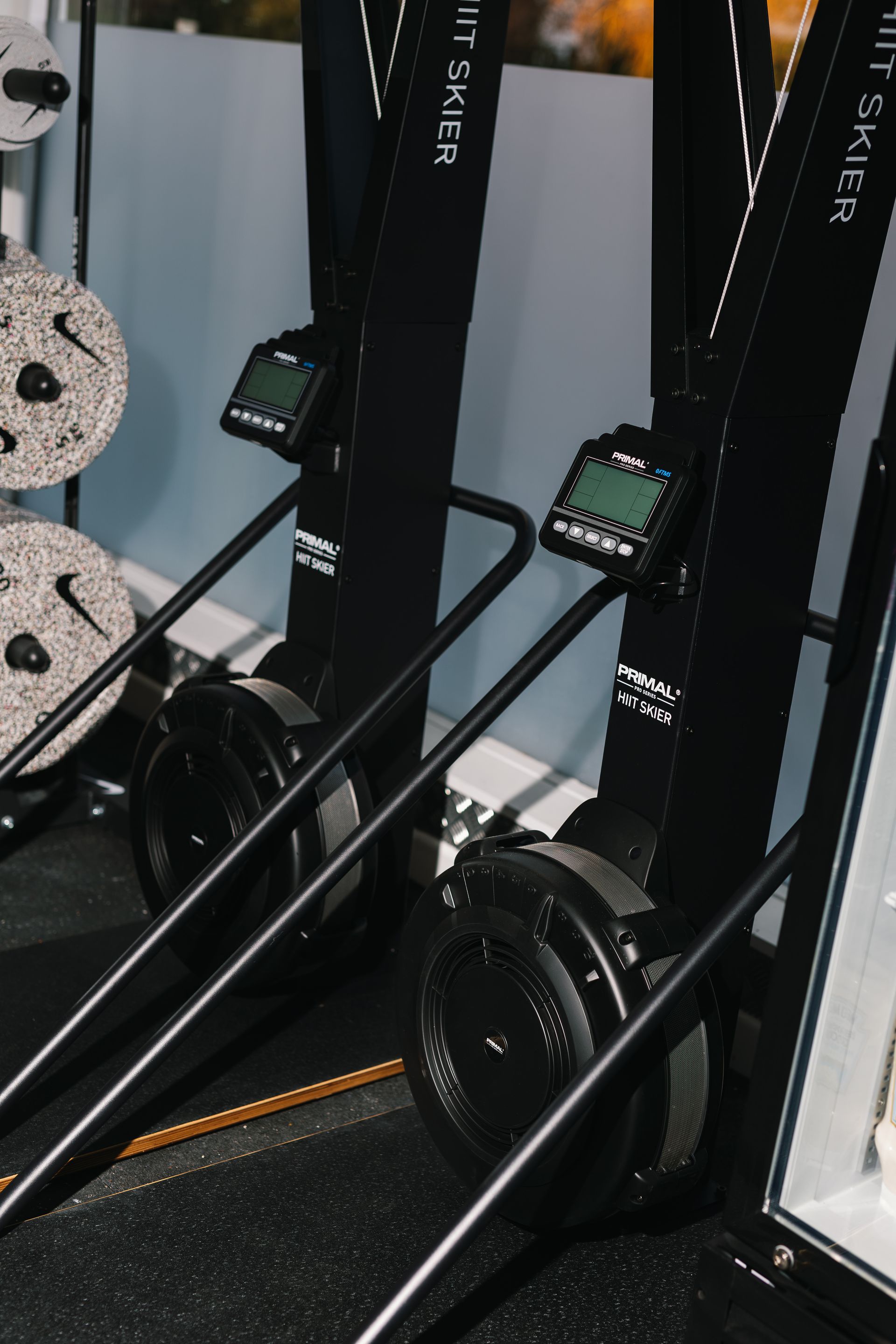 A man is sitting on a bench in a gym lifting weights.