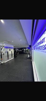 A gym with a lot of weights on the racks