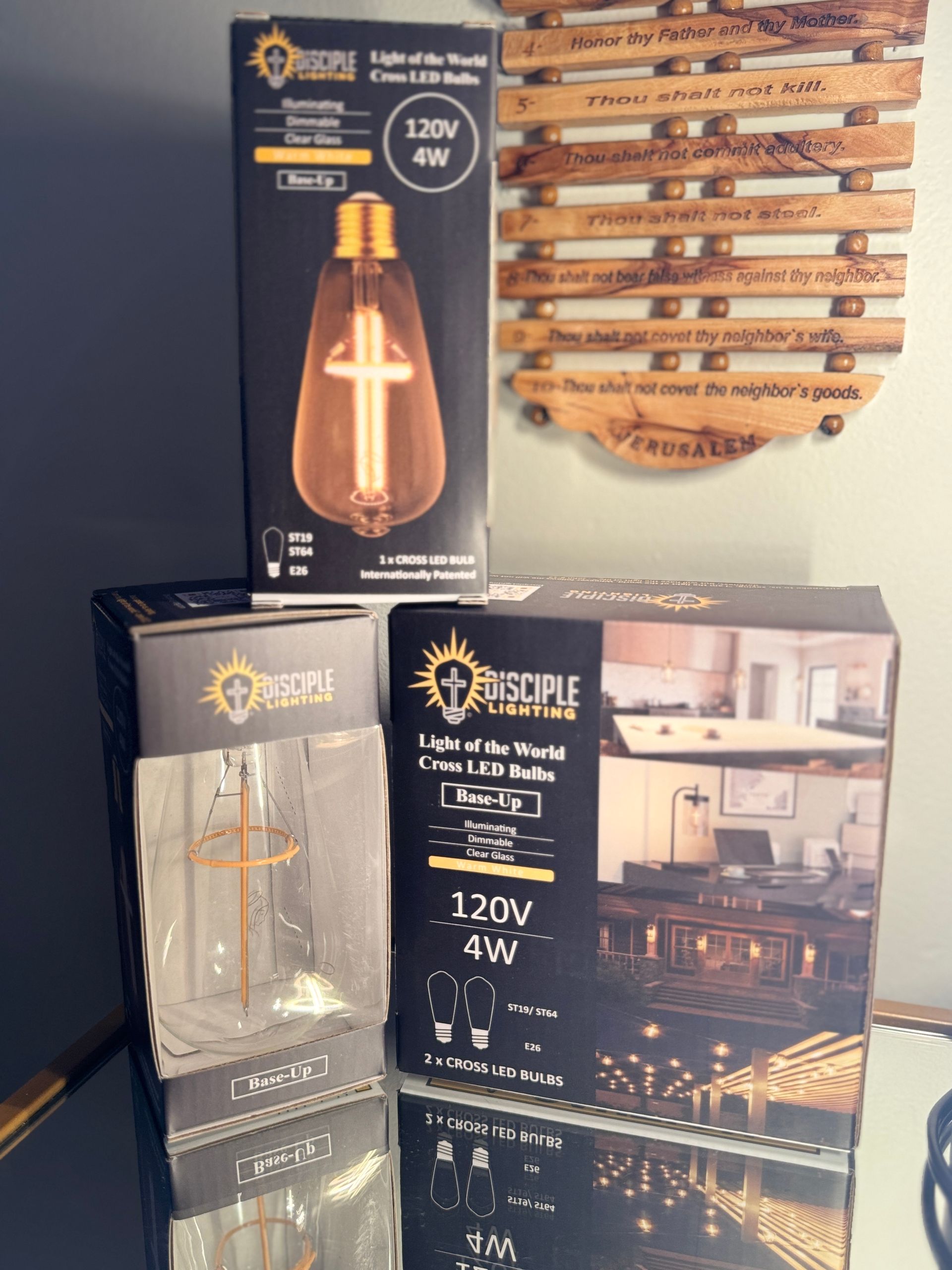 Boxes of LED light bulbs on a table; one is shaped like a cross and another showing a kitchen setting.