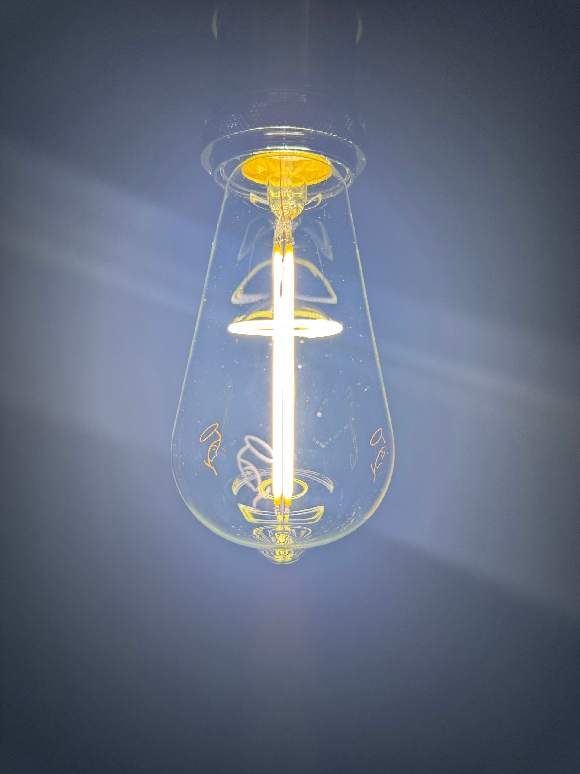 Glowing Edison bulb against a dark blue background.