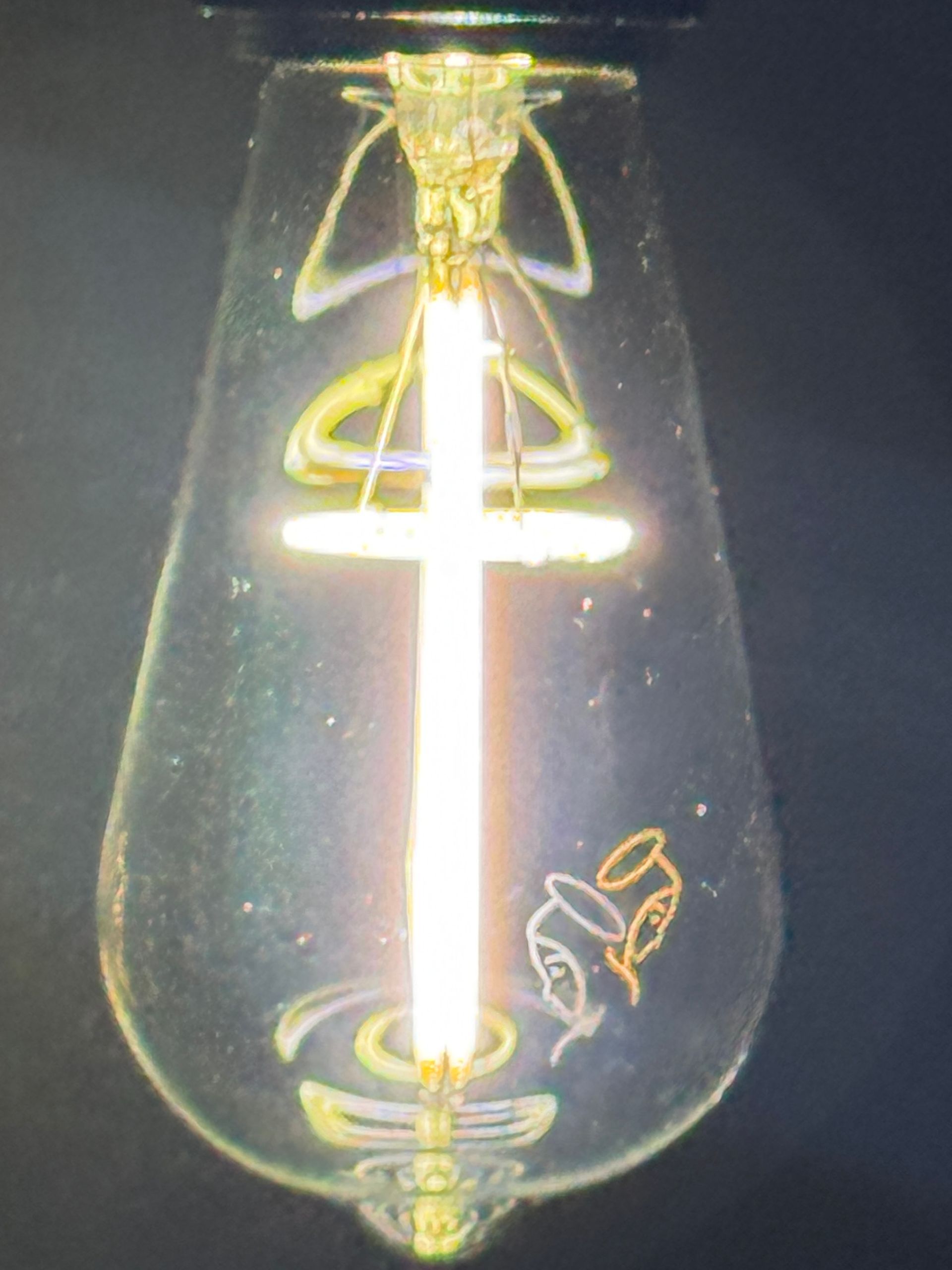 Lightbulb with a cross filament and angel outline.