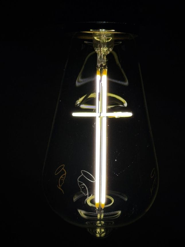Lit LED light bulb against a black background.