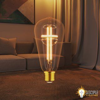 A decorative lightbulb with a cross filament, in a living room setting.