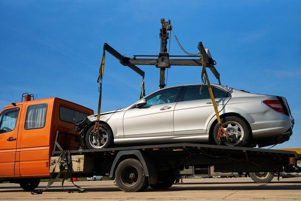 A White Car is Being Towed by a Tow Truck — Bulahdelah Towing In Coolongolook, NSW