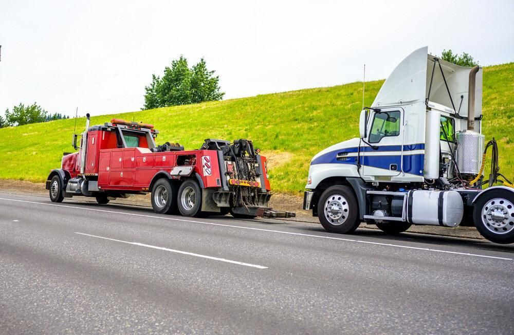 A Tow Truck is Towing a Semi Truck on the Side of the Road — Bulahdelah Towing In Tea Gardens, NSW