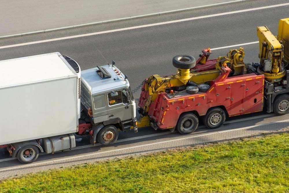 A Truck is Being Towed by a Tow Truck on the Side of the Road — Bulahdelah Towing In Stroud, NSW