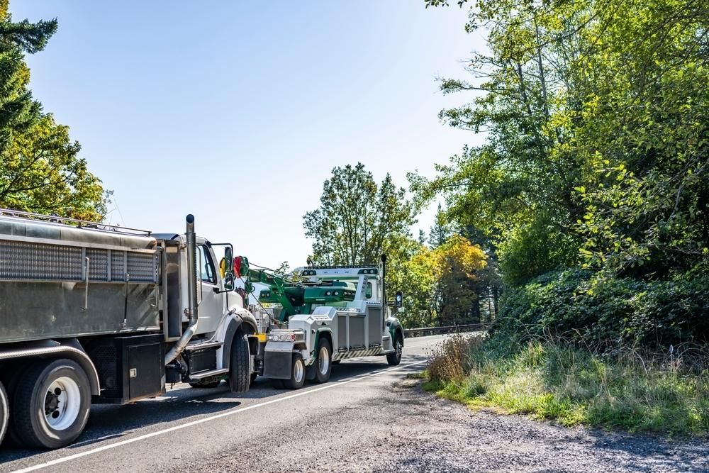 Two Dump Trucks Are Parked on the Side of a Road — Bulahdelah Towing In Karuah, NSW
