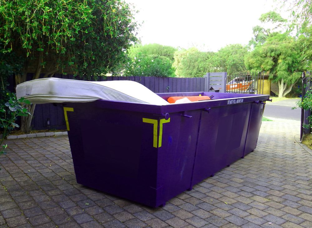 Purple Dumpster on a Brick Driveway — Tamworth Skips and Rubbish Removal in Quirindi, NSW