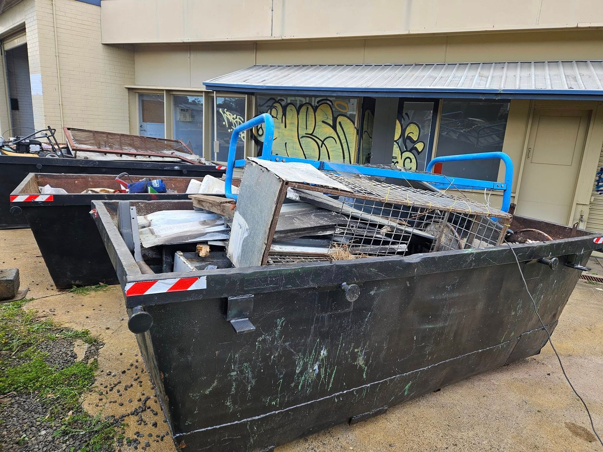 Dumpster in Front of a Building With Graffiti — Tamworth Skips and Rubbish Removal in South Tamworth, NSW