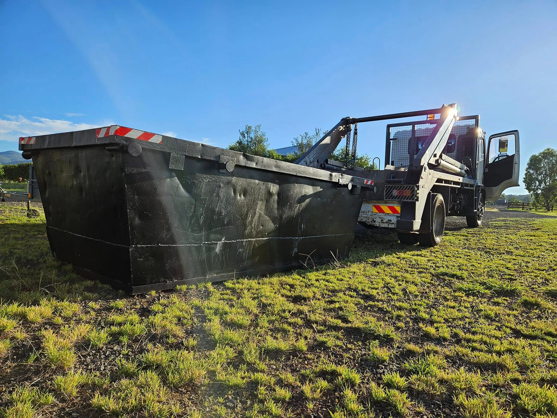 A Black Roll-off Container on a Truck — Tamworth Skips and Rubbish Removal in Manilla, NSW