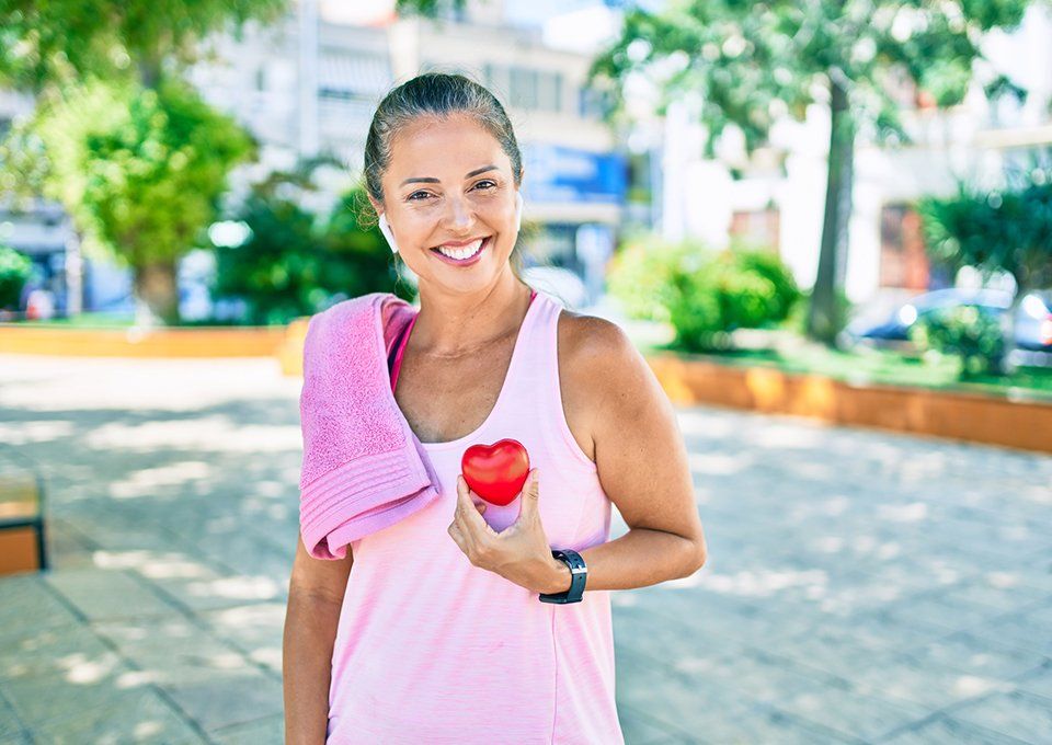 Middle Age Sportswoman Holding Heart — Cody, WY — A Woman's Place LLC Lisa Williams, MD