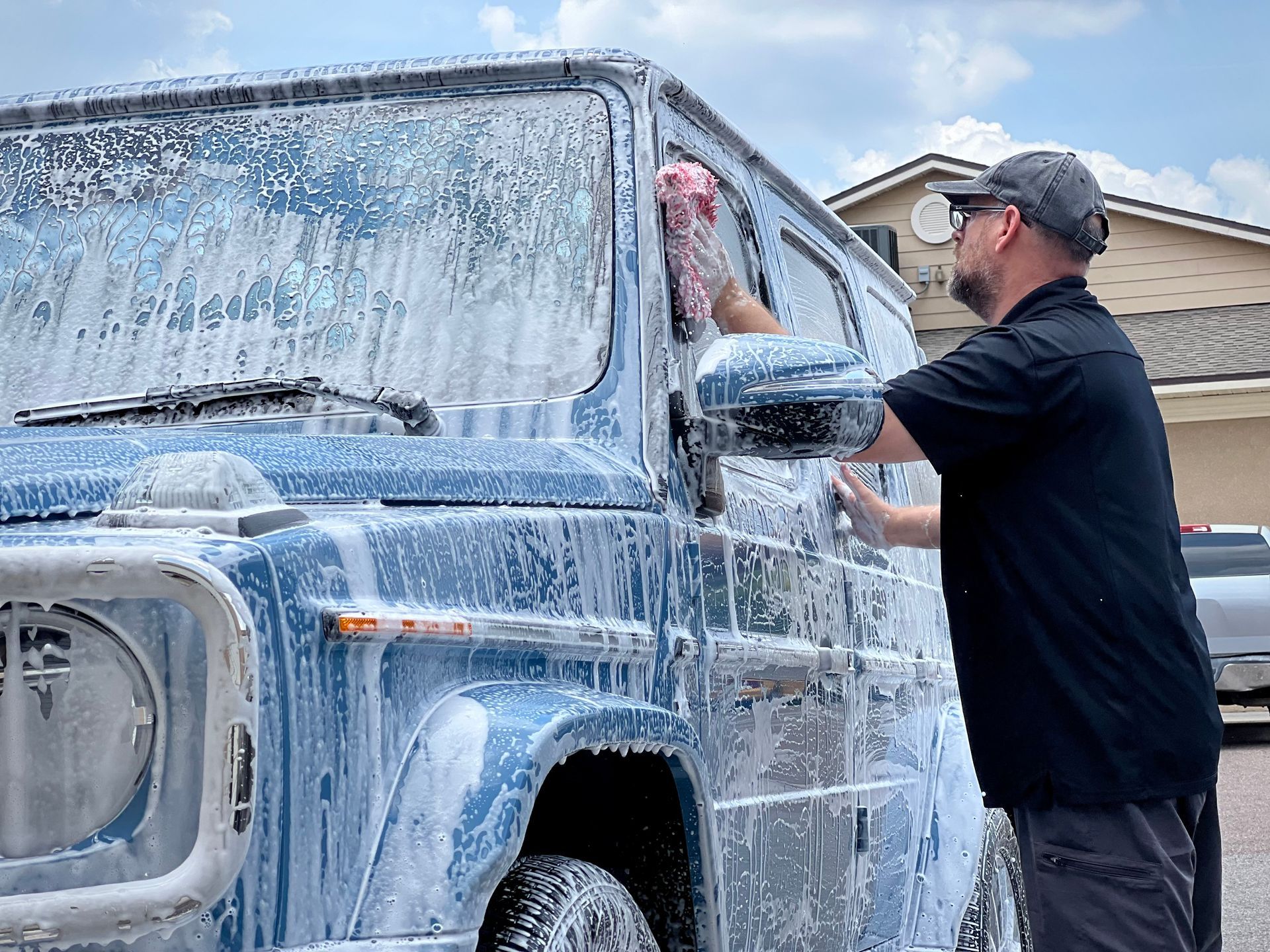 A car is being washed with foam in a garage.