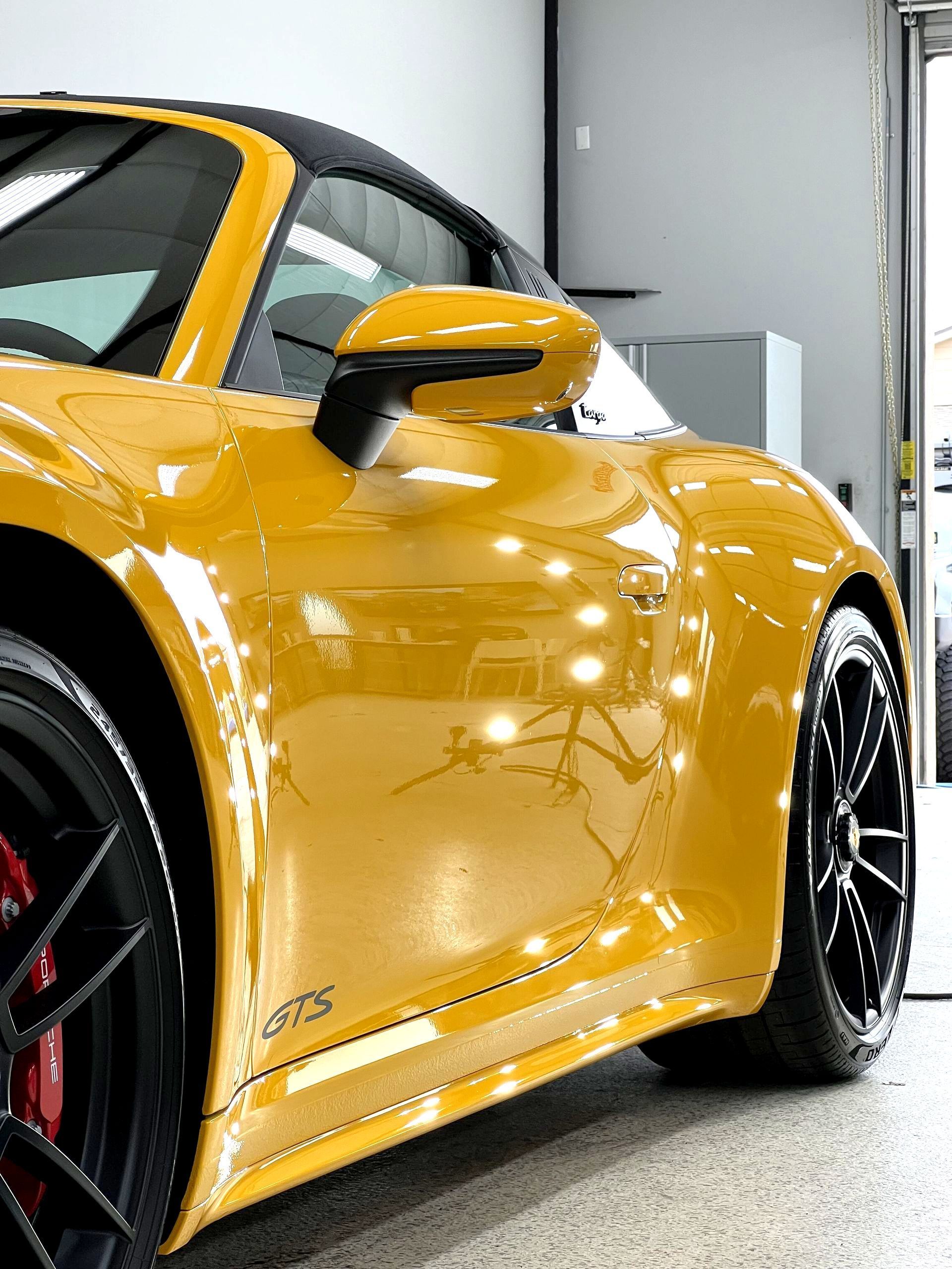 A yellow sports car is parked in a garage.