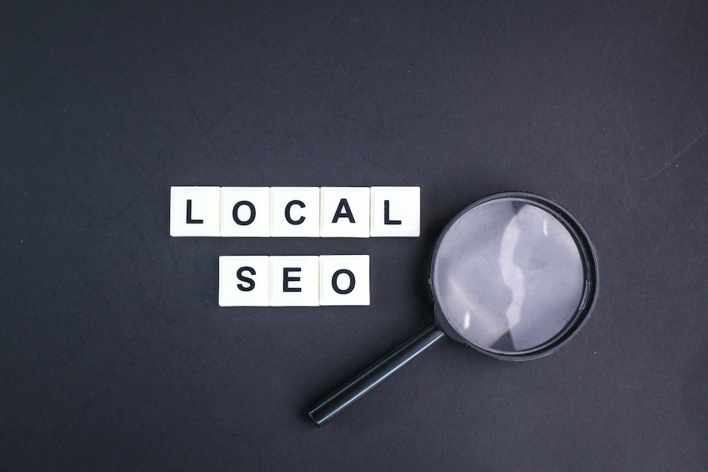 A magnifying glass is sitting next to a sign that says local seo