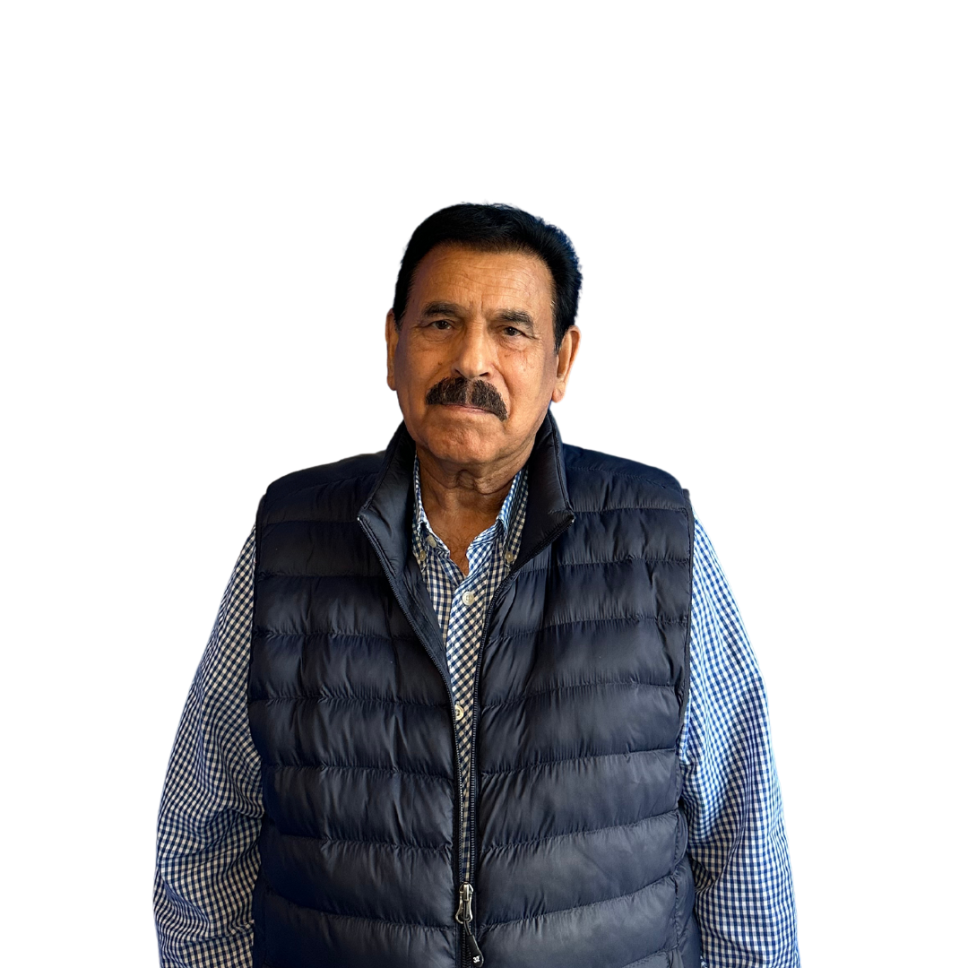 A man with a mustache is wearing a black vest and a plaid shirt.