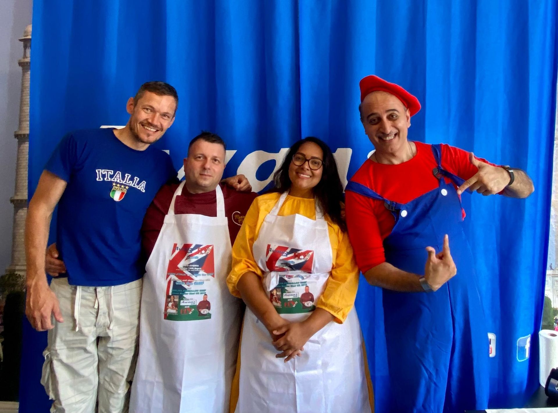 A group of people are posing for a picture in front of a blue curtain.