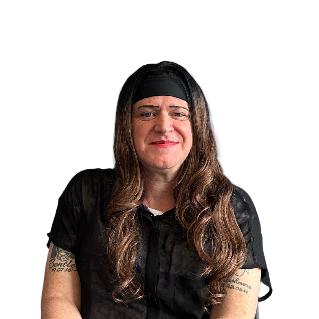 A man wearing a wig and a headband is smiling.