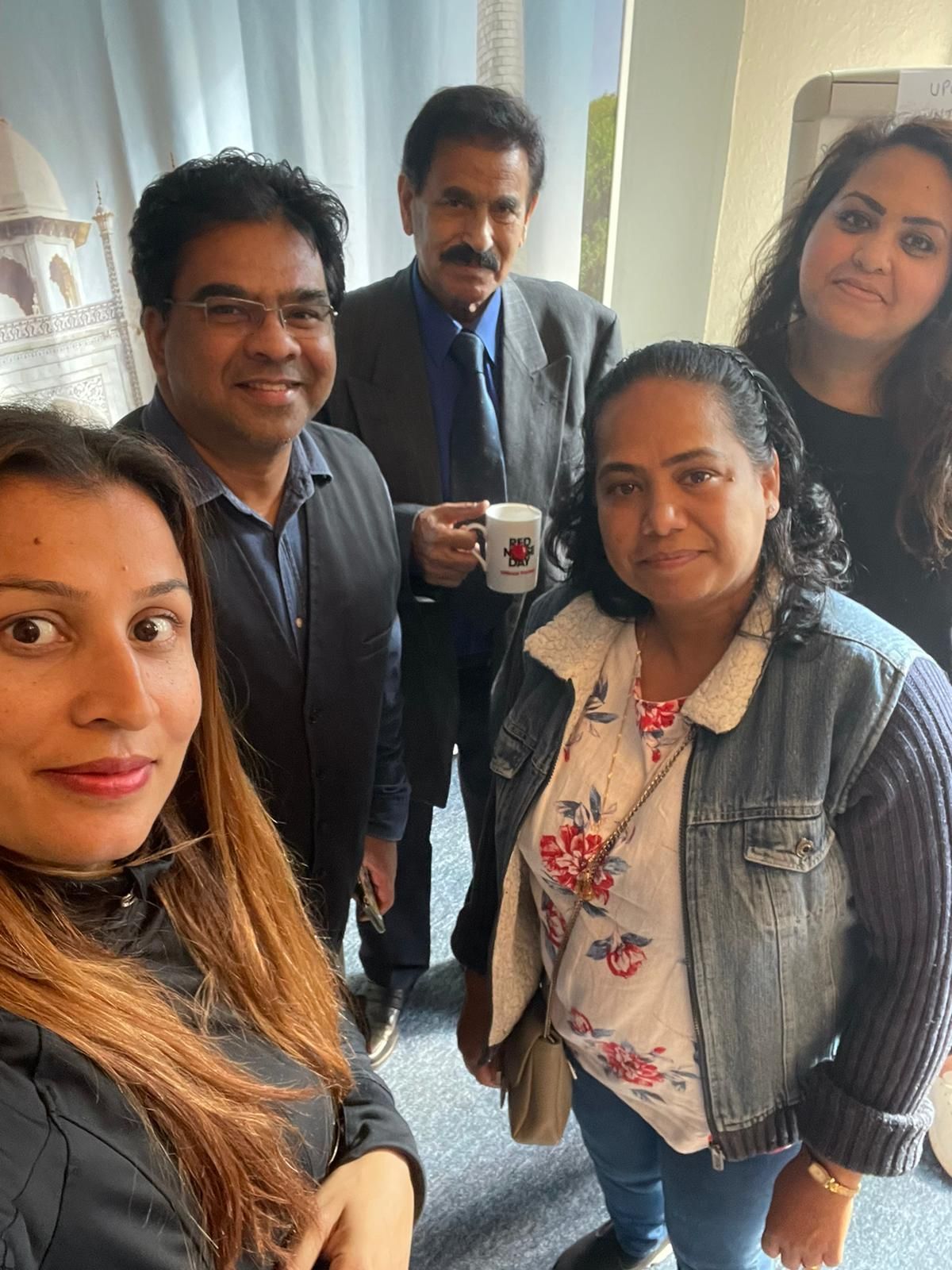 A group of people are posing for a picture in a room.