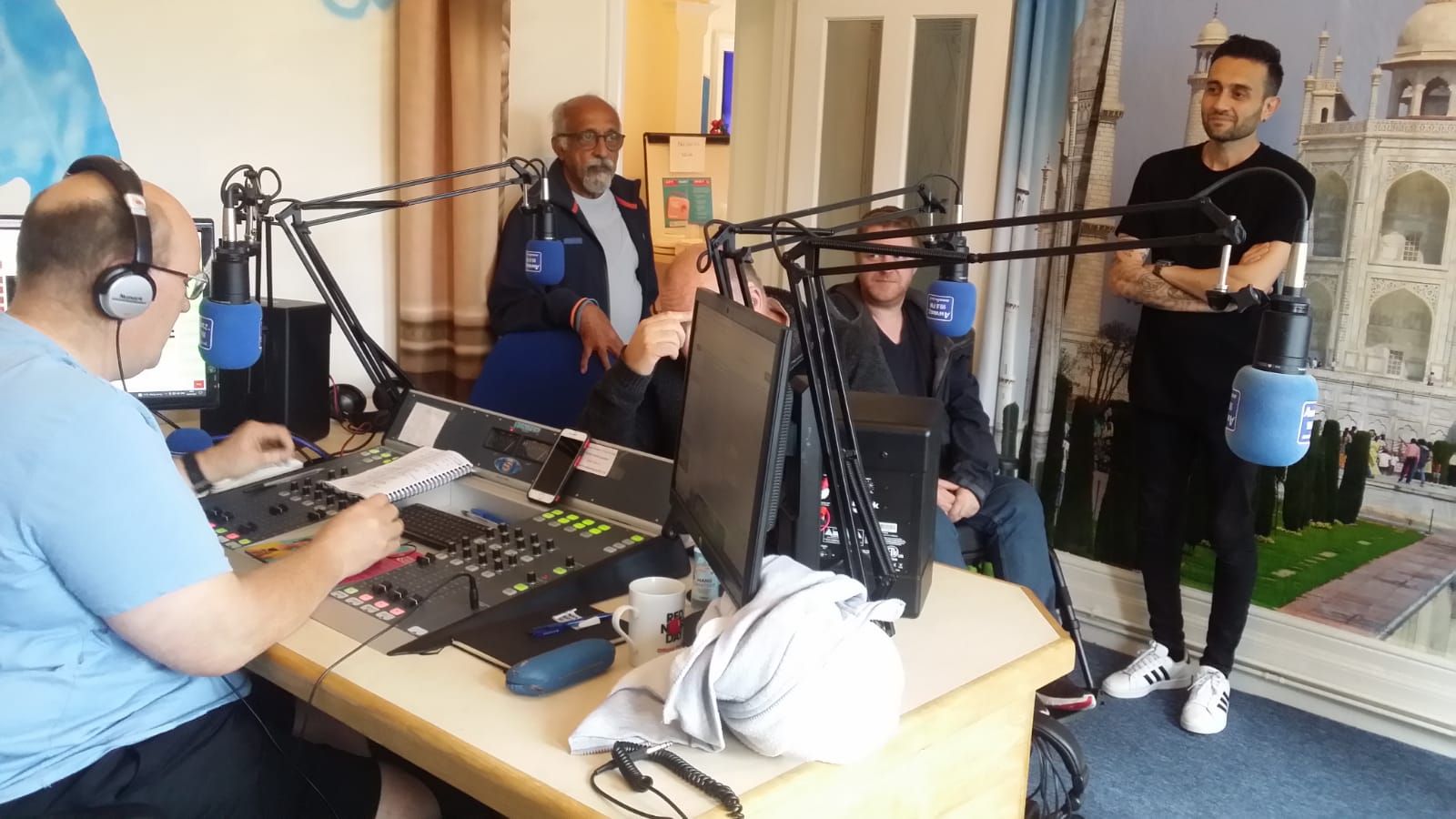 A group of men are sitting at a table in front of microphones.