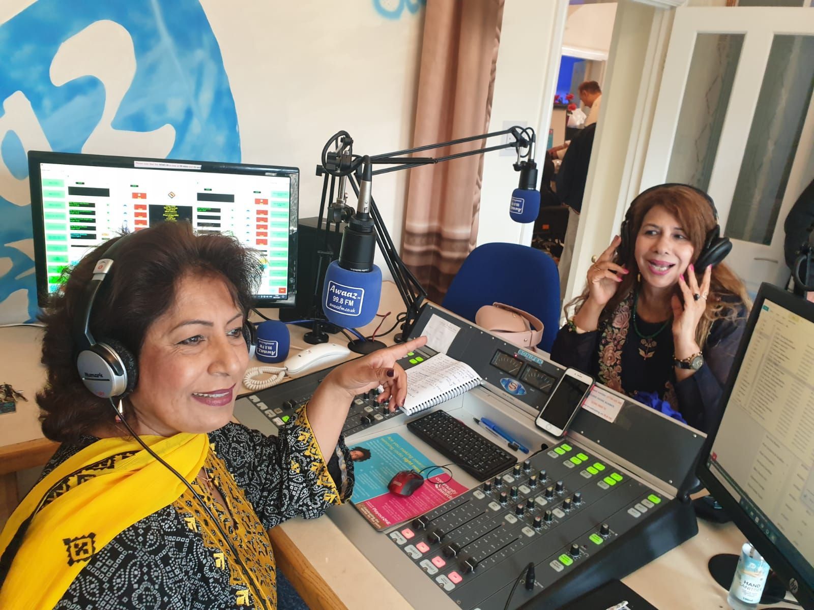 A woman wearing headphones is talking into a microphone