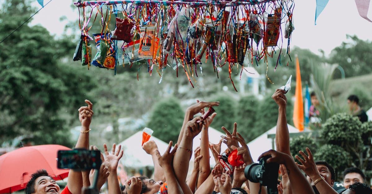 A crowd of people are raising their hands in the air at a festival.