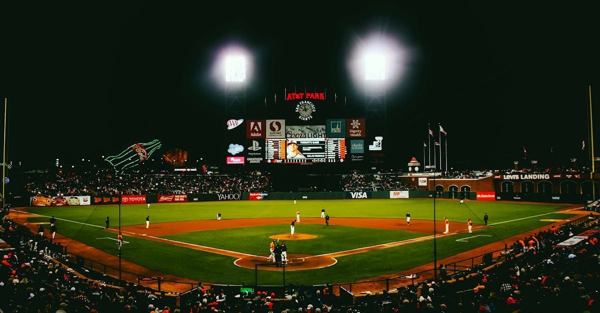 A baseball game is being played in a stadium at night.