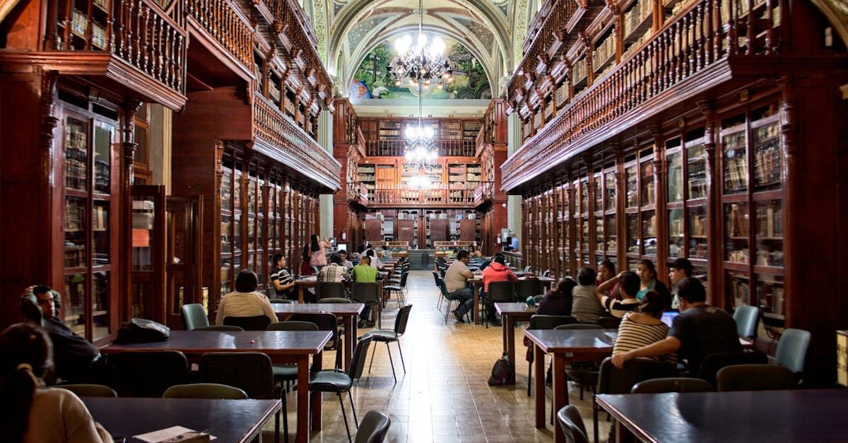 A group of people are sitting at tables in a library.