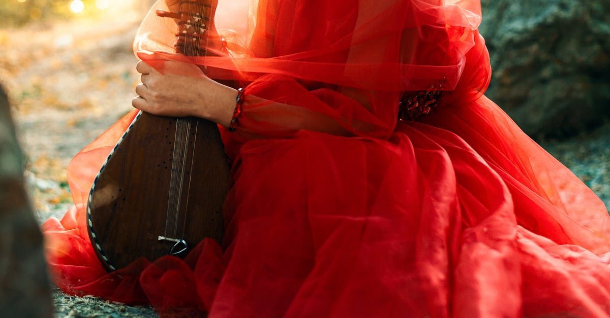 A woman in a red dress is holding a guitar.