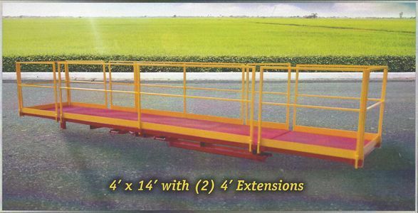 Yellow metal platform with guardrails on asphalt in front of a green field, labeled as 4' x 14' with (2) 4' Extensions.