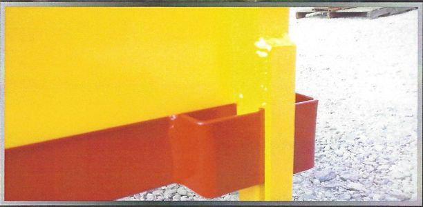 A yellow metal structure with a red horizontal bar and two red square extensions.