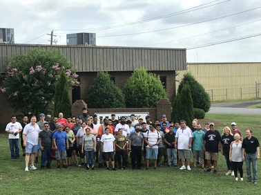 A large group of people are posing for a picture in front of a building.