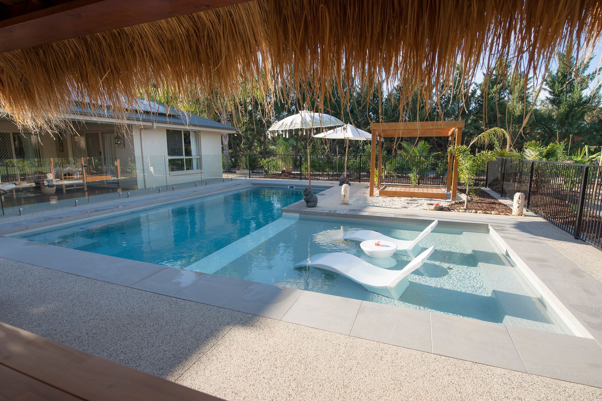 Pool With Lounge Chairs and White Patio Furniture in a Sunny Outdoor Setting — Swan Hill Pool & Spa Centre in Swan Hill, VIC