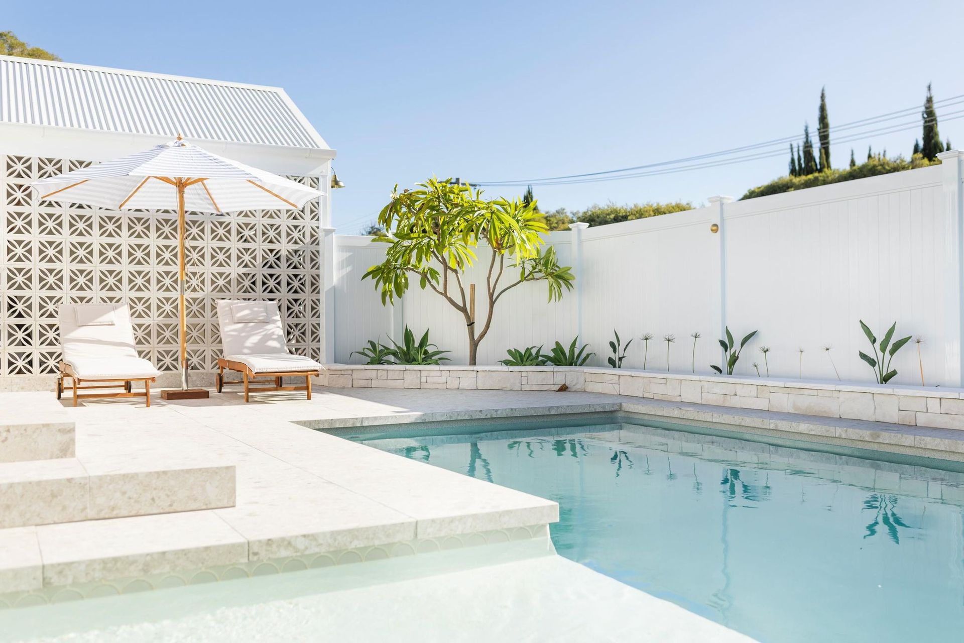 Poolside Scene White Patio, Pool, Lounge Chairs Under an Umbrella — Swan Hill Pool & Spa Centre in Swan Hill, VIC