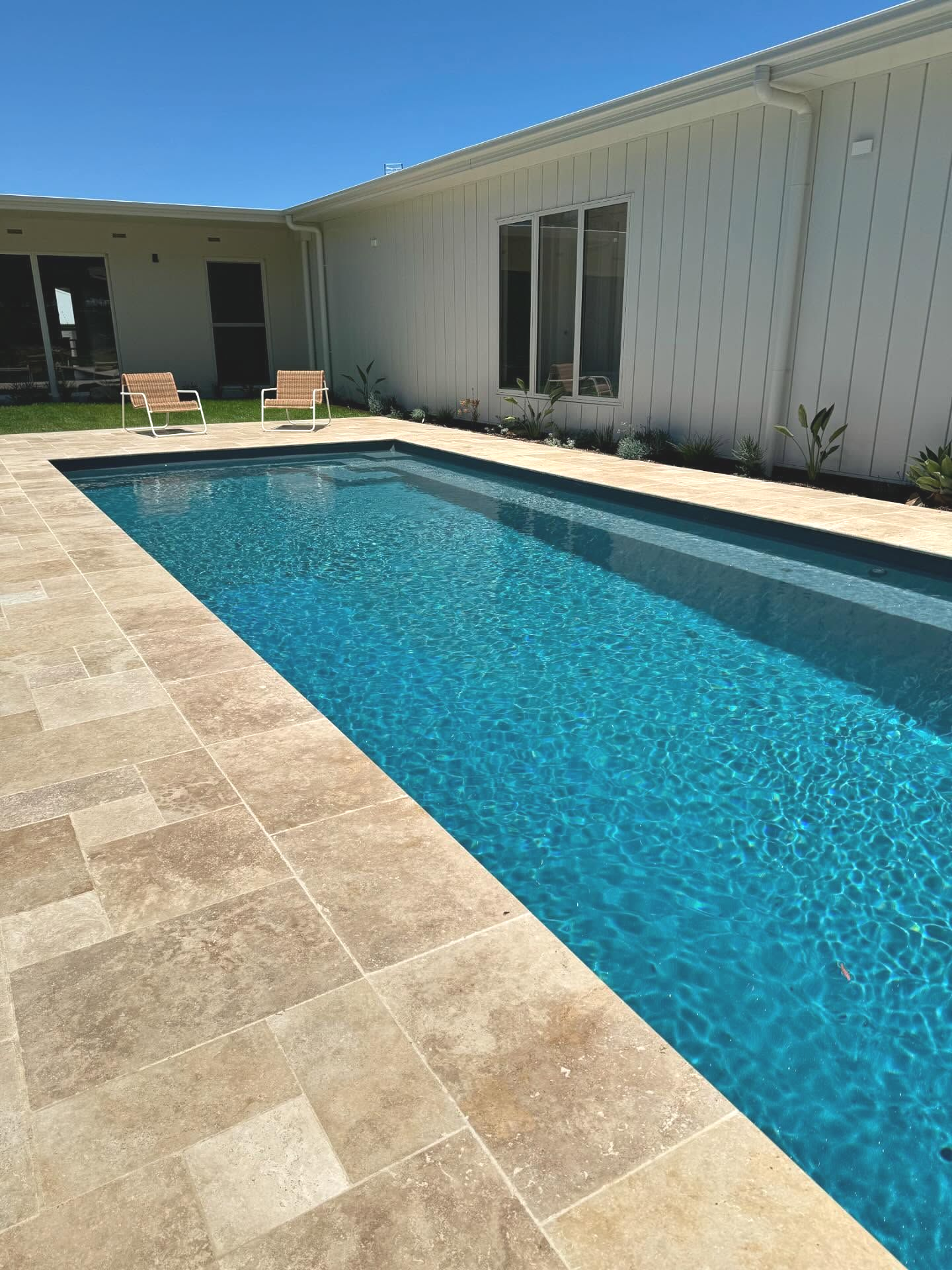 Swimming Pool With Blue Water, Surrounded by Beige Stone — Swan Hill Pool & Spa Centre in Swan Hill, VIC