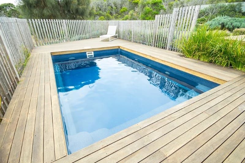 Swimming Pool with Blue Water Surrounded by Wooden Deck — Swan Hill Pool & Spa Centre in Swan Hill, VIC
