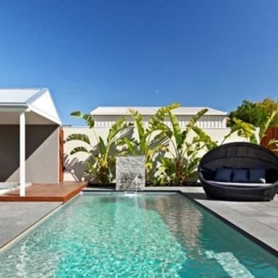 Pool with Lounge Area, Blue Sky and A White Building — Swan Hill Pool & Spa Centre in Swan Hill, VIC