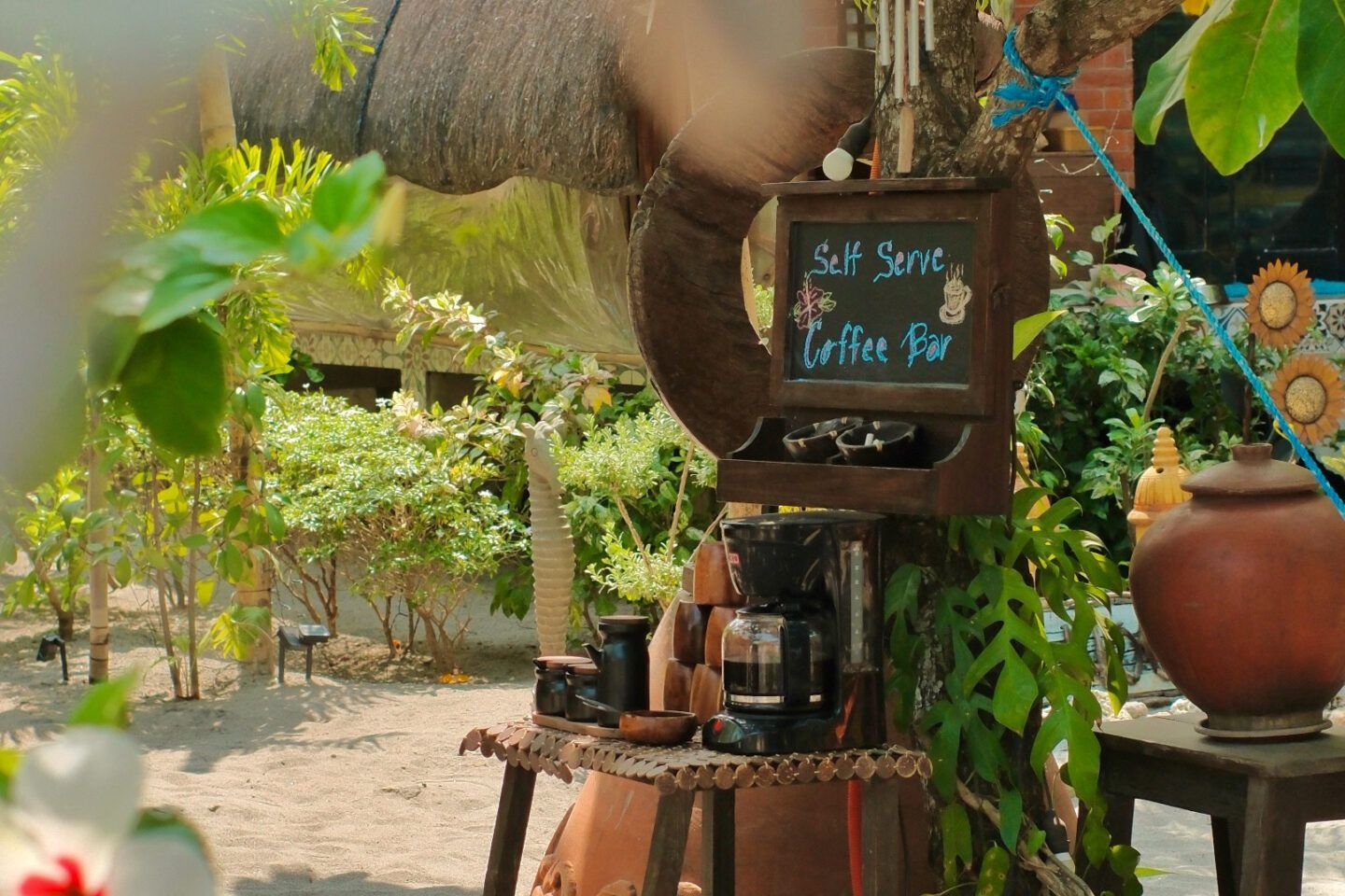 A coffee bar with a sign that says ' self serve coffee bar ' on it.