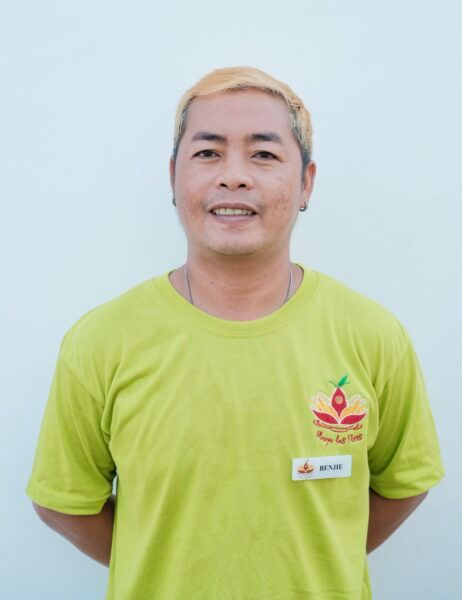A man wearing a green t-shirt with an apple on it