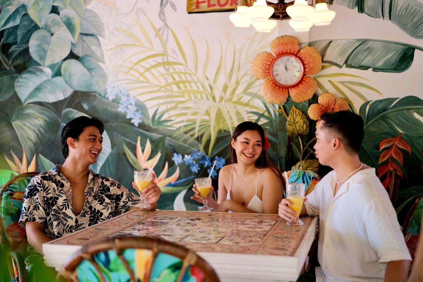 A group of people are sitting at a table holding drinks.
