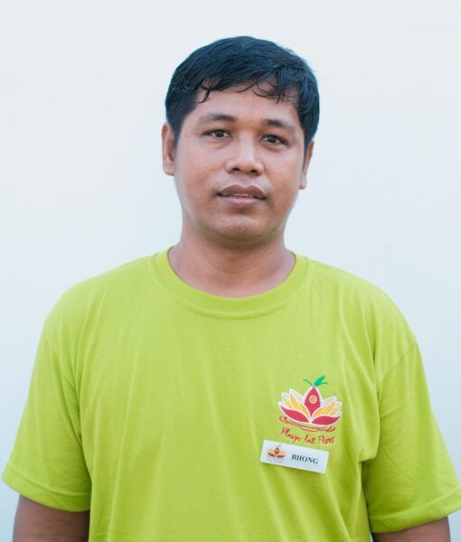 A man wearing a green shirt with a flower on it
