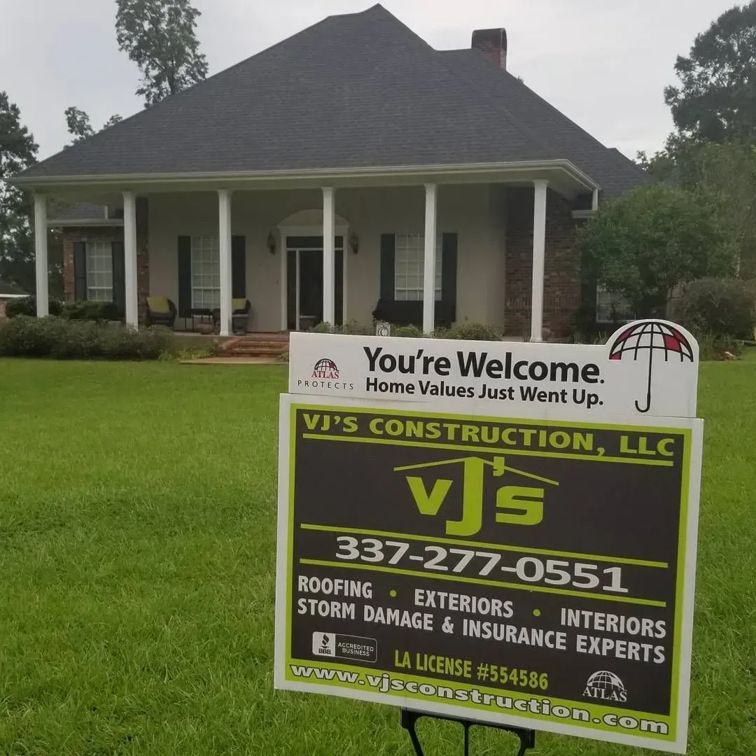 A house with a sign for VJ's Construction; offering roofing, exteriors, and interiors services.