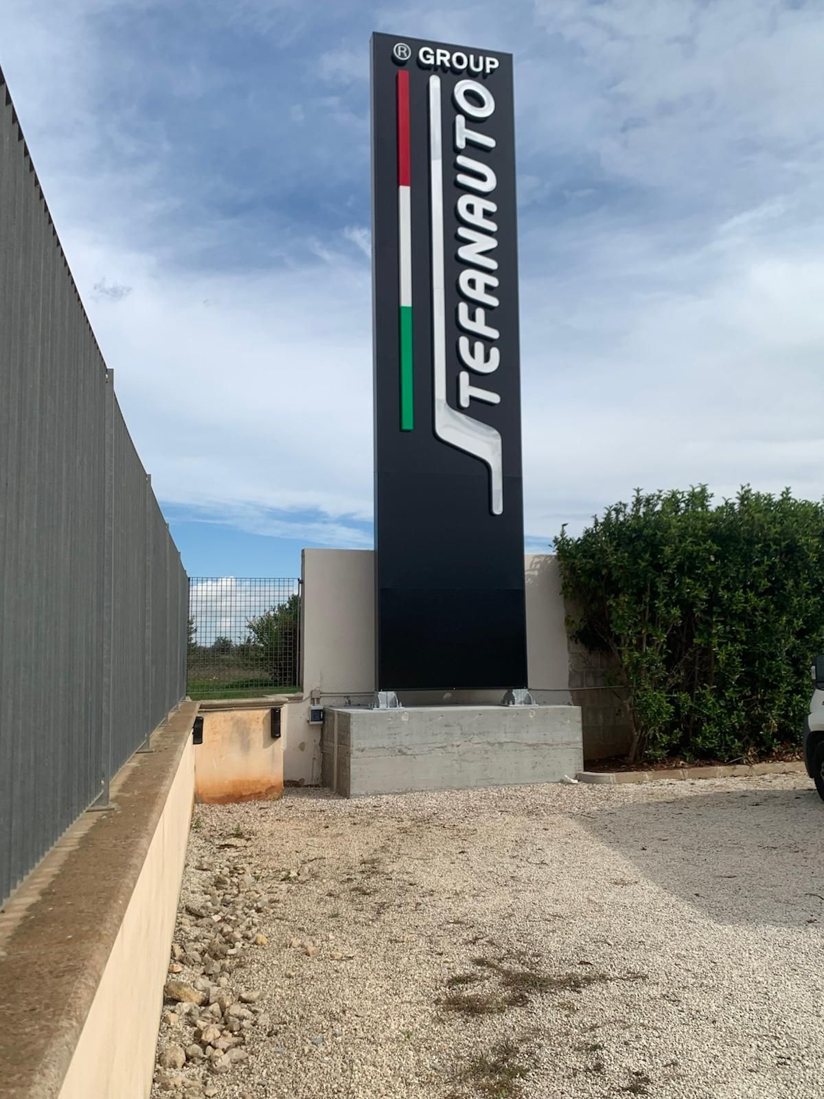 Insegna della casa automobilistica Tefanauto, con i colori della bandiera italiana e sfondo nero.