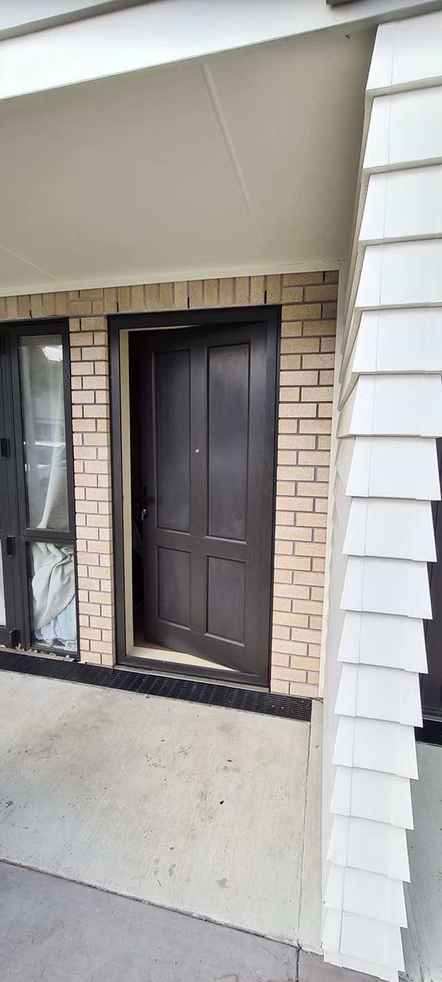 A brick building with a black door and windows.