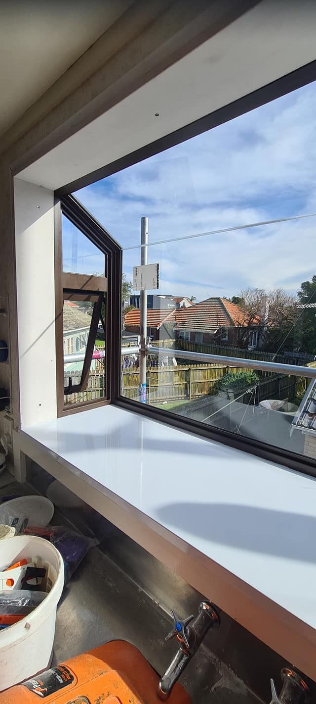 A window with a view of a city is being built in a kitchen.