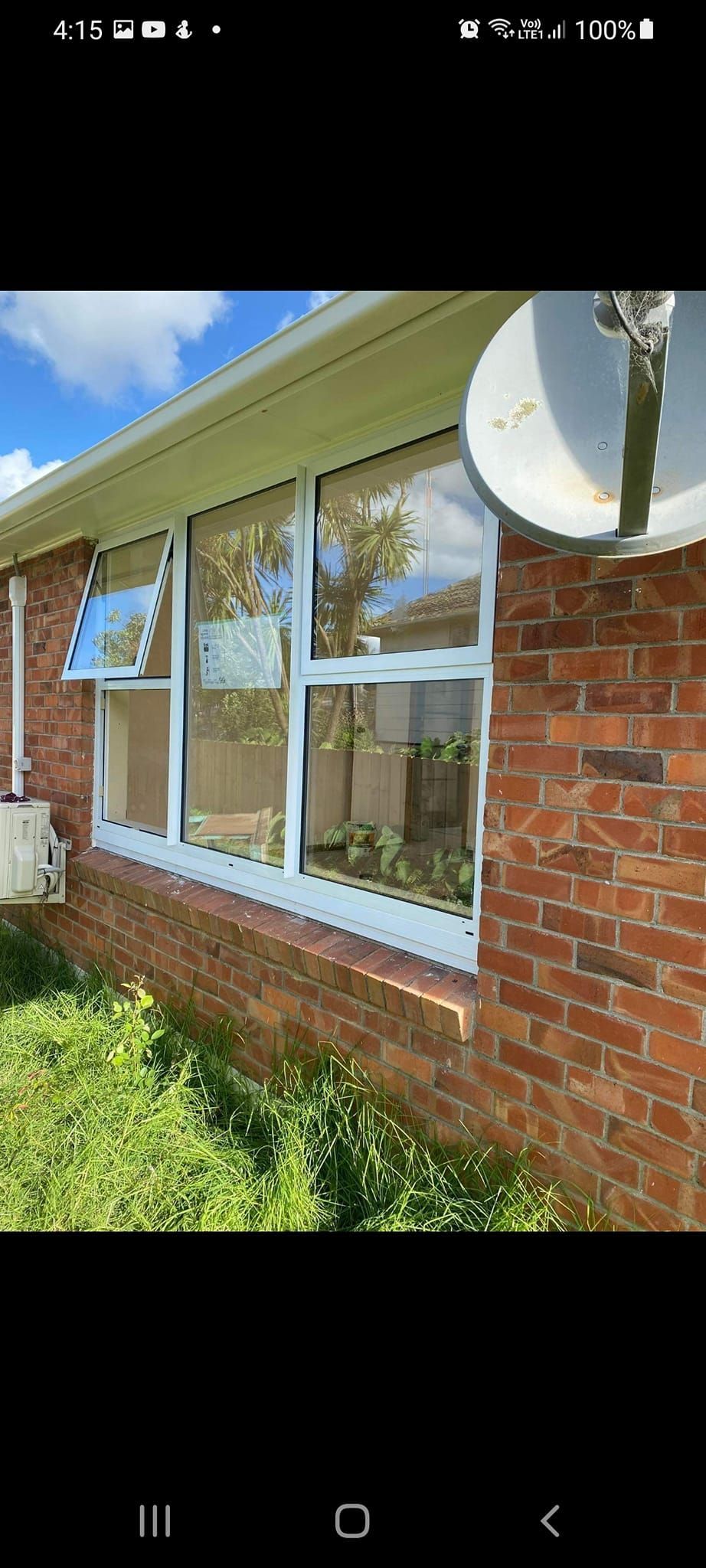 A brick house with a satellite dish on the side of it.