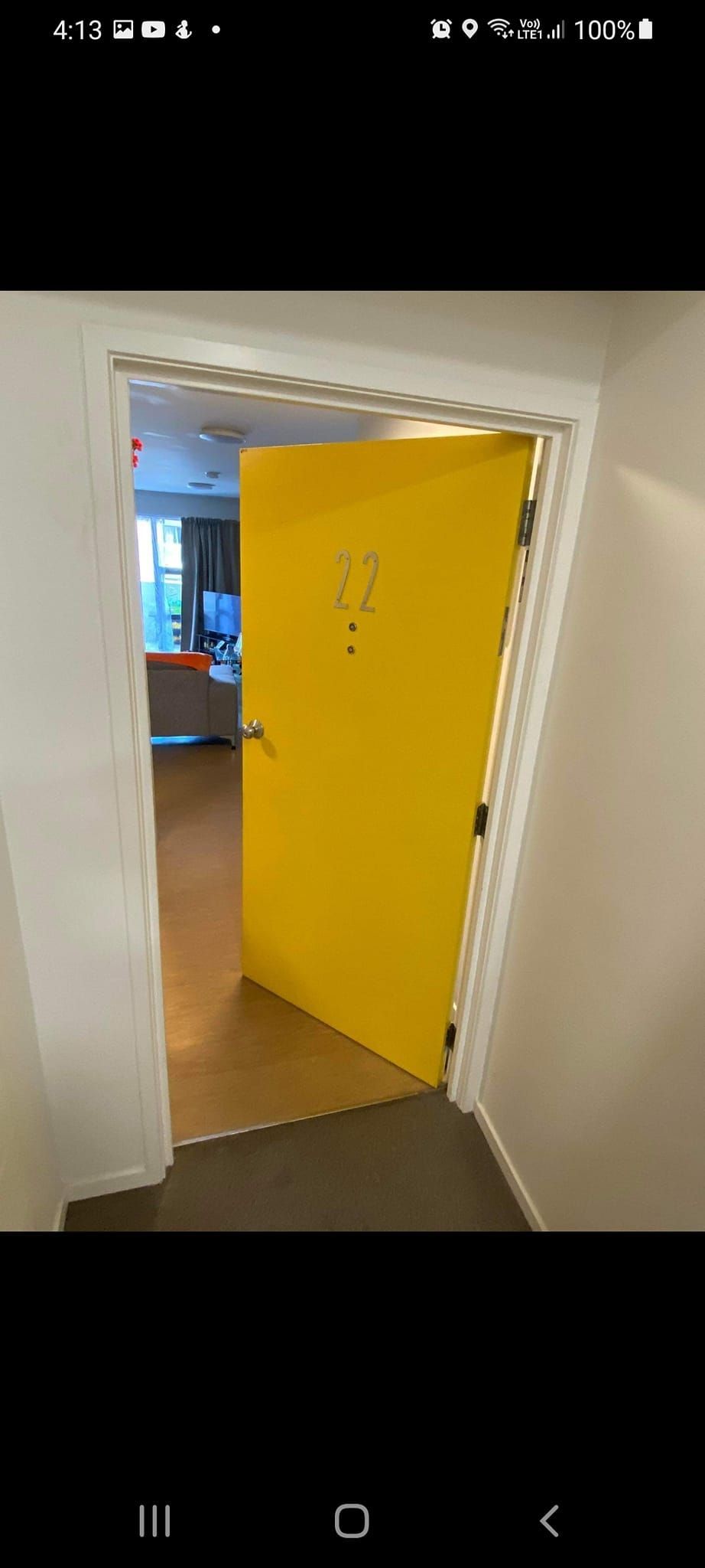 A picture of a door in a hallway on a cell phone.