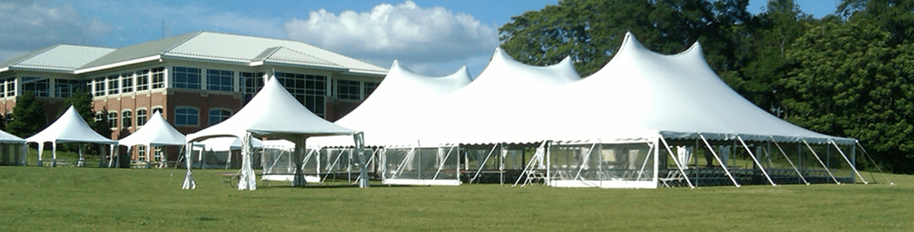 A Row of White Tents in a Field With a Building in the Background
