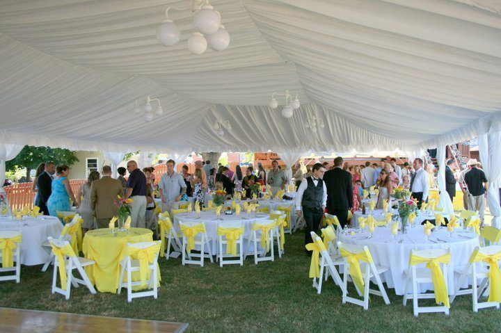 A Large Tent With Tables and Chairs Set Up for a Wedding Reception